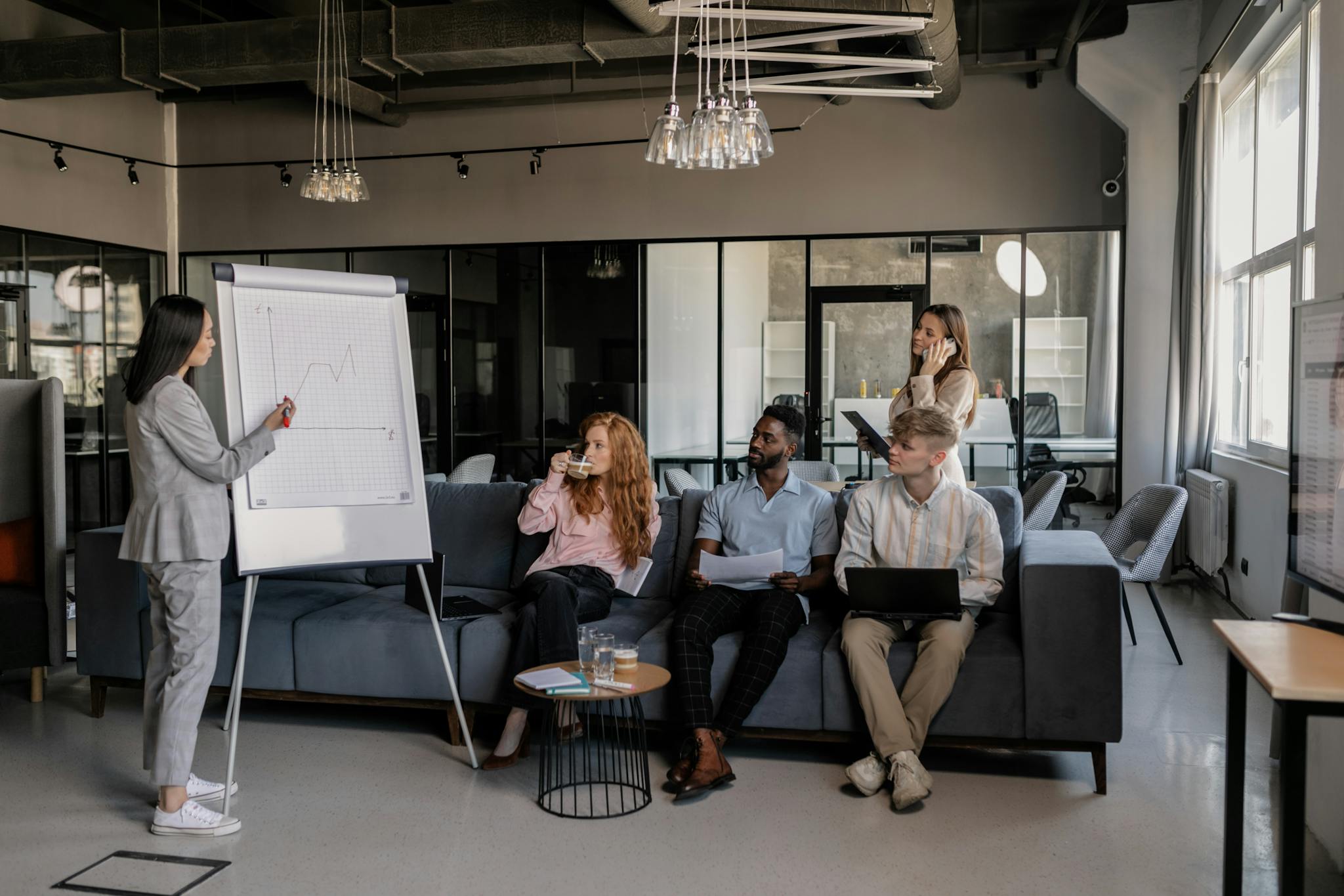 A multicultural team conducts a presentation in a modern office setting, highlighting teamwork and collaboration.
